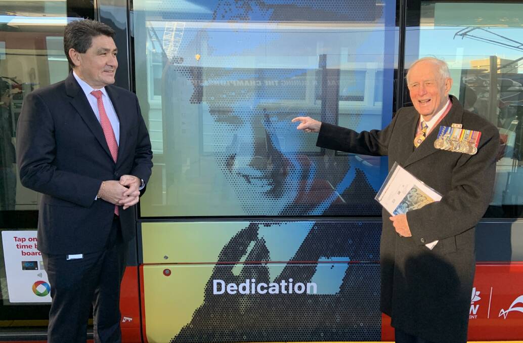 LEST KOREA FORGET: Rear Admiral (Ret'd) Ian Crawford in front of his image on a light rail carriage, with Acting Veterans Minister Geoff Lee. 