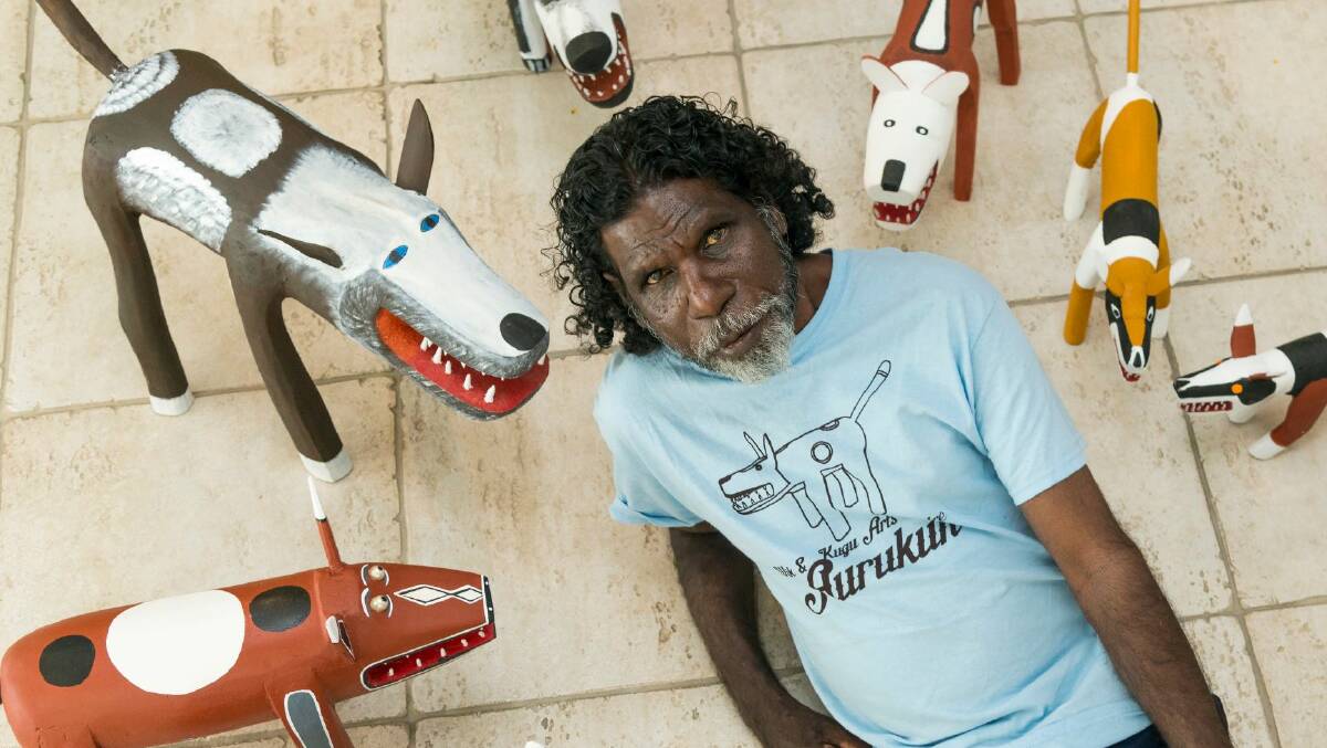 Aurukan Garry Namponan with camp dog carvings.